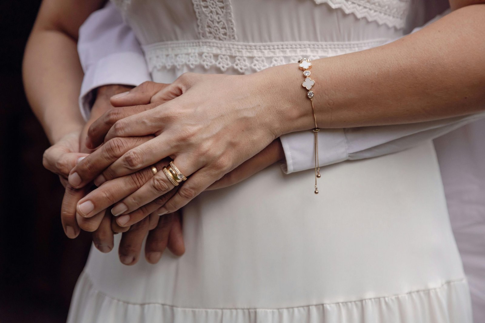 Close-up of a couple's hands, symbolizing unity and love, with wedding rings visible.